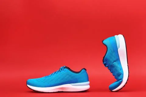 Blue running sneaker on red background, close up Stock Photos
