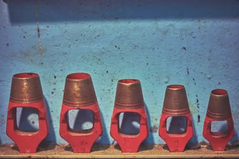 Blue rustic shelf with plenty hanging red hole punchers Stock Photos