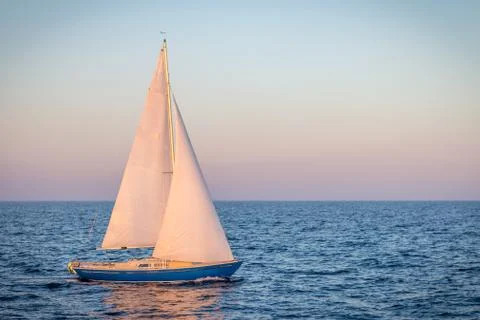 Blue sailboat in the ocean Stock Photos