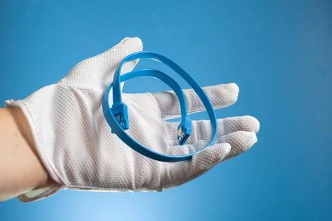 Blue SATA interface cables in a hand on a blue background. Computer concept. Stock Photos