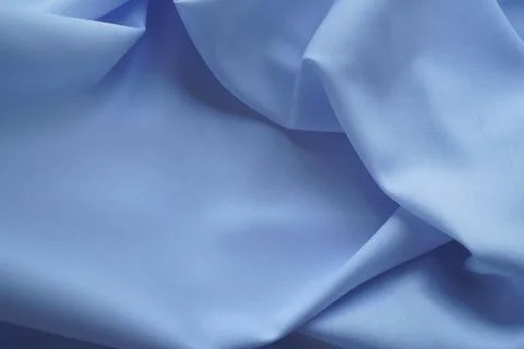 Blue satin with soft pleads. Close-up. A textured background. Stock Photos
