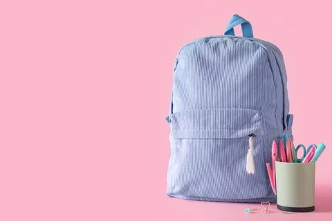 Blue school backpack with different stationery on pink background Stock Photos
