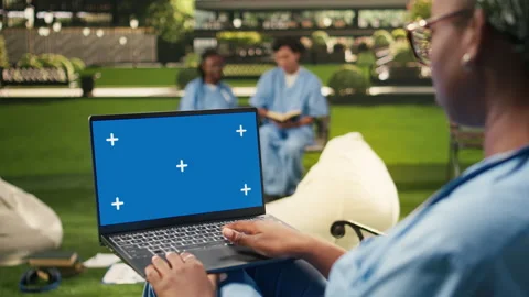Blue screen chroma key on laptop held by black medical student Stock Footage 340962917