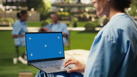 Blue screen laptop mockup held by student using touchpad with one hand Stock Footage 340961472
