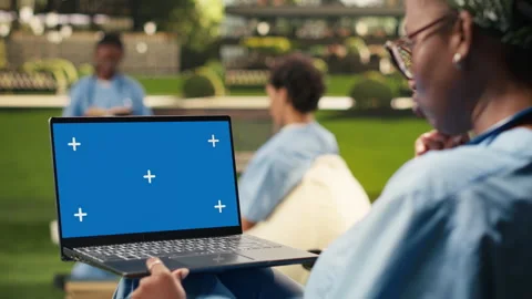 Blue screen laptop mockup held by student using touchpad with one hand Stock Footage 340961473