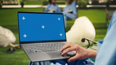 Blue screen laptop mockup held by student using touchpad with one hand Stock Footage 340963077