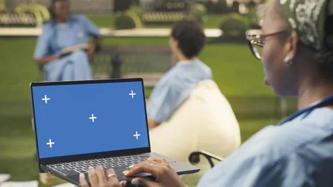 Blue screen laptop mockup held by student using touchpad with one hand Stock Photos