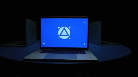 Blue screen laptops circling from one laptop to another wide shot 動画素材 220533072