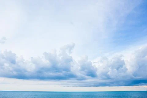 Blue sea and cloudy sky over it Stock Photos