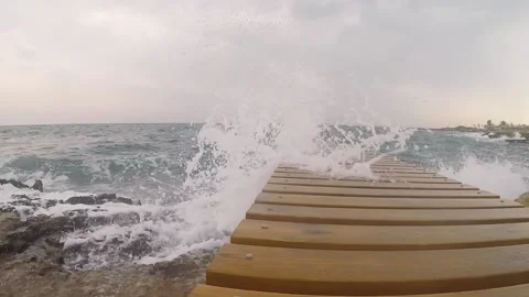 Blue sea. big waves. Splashes of water. The wooden pier. Bridge into the wate Stock Footage 145193791