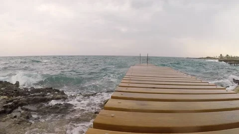 Blue sea. big waves. Splashes of water. The wooden pier. Bridge into the wate Stock Footage 145193839