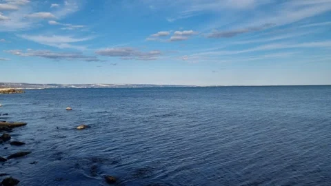 Blue sea with clouds and distant coastline under bright sky Stock Footage 320455471
