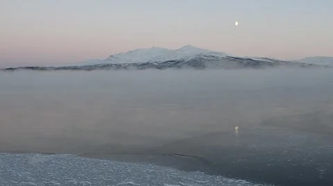 Blue sea ice, thick ice fog, snowy mountain and moon in winter Stock Footage 47262328