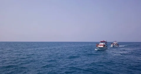 Blue sea / ocean, which sails two white yachts with young tanned guys and girls Stock Footage 105237534