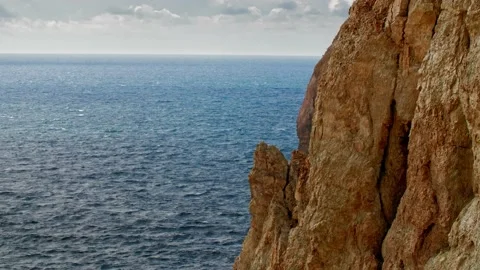 A blue sea over an overcast sky. In the foreground on the right is a textured Stock Footage 218405455