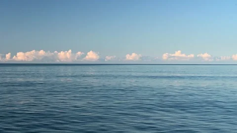 A blue sea, reflecting the clouds in the sky. Stock Footage 303645700