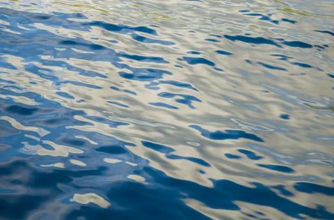 Blue sea surface background with waves. Silky texture of ocean water. Stock Photos