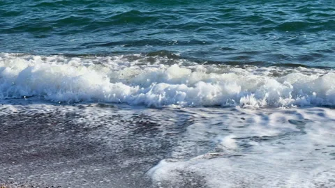 Blue sea wave rolling onto coast frothy white foam under sunlight, Stock-Footage 335252606