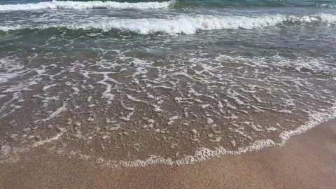 Blue sea waves breaking on sandy coastline 動画素材 329319769