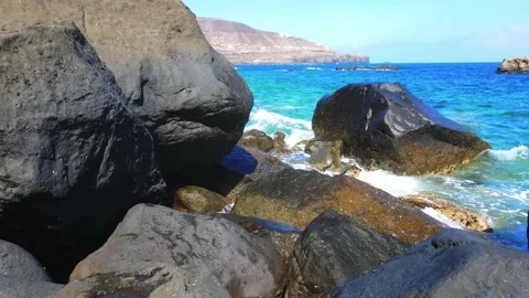 Blue sea waves going against the rocks Stock Footage 148678295