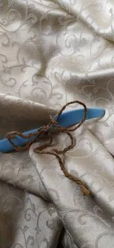Blue sewing pin with brown thread on patterned fabric Stock Photos