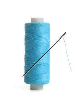 Blue sewing thread spool with needle isolated on white background, closeup Stock Photos