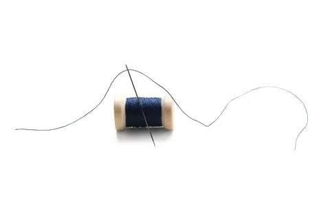 Blue sewing thread spool with needle isolated on white background, closeup Stock Photos