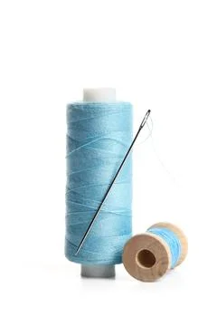 Blue sewing thread spools with needle isolated on white background, closeup Stock Photos