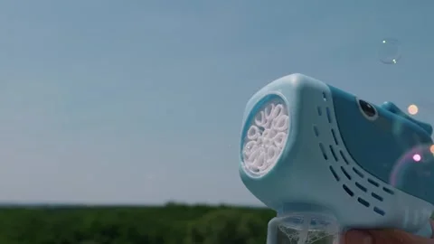 Blue Shark Toy Bubble Gun Blowing Soapy Bubbles Against Blue Sky Stock Footage 339176531