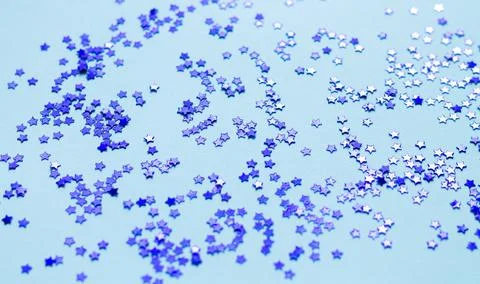 Blue shiny stars glitter or confetti on gray background Stock Photos