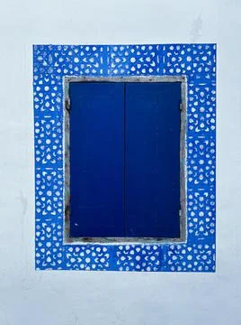 Blue simplistic closed window in the old medina of Asilah Stock Photos