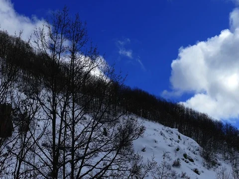 Blue Skies and Clouds over Hills with Snow Stock Footage 74334696