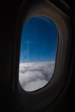 Blue Sky Above Clouds Through Airplane Window Stock Photos