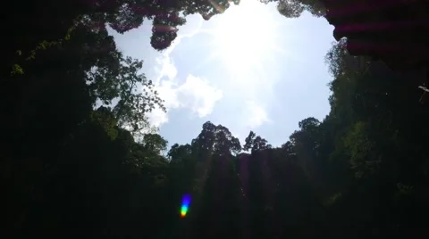 Blue sky and bright sun view from bottom of cave, ceiling gap opening 스톡 동영상 50566409