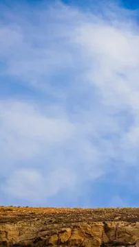 Blue sky and clouds above a narrow rocky ridge Foto stock