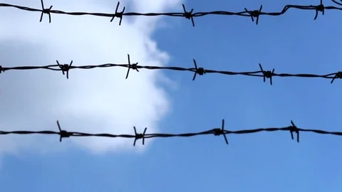 Blue sky and clouds behind the barbed wire. Stock Footage 73543836