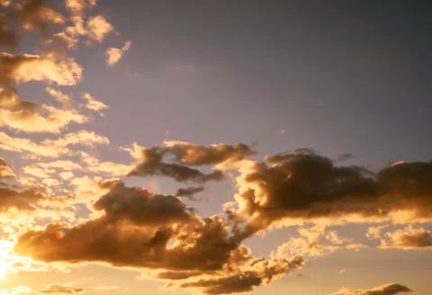 Blue sky and clouds being illuminated by a setting sun Stock Photos