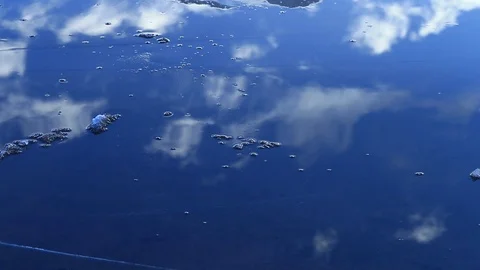 Blue Sky and Clouds Reflected in Puddle with Reflection of Bicycle Stock Footage 103499267