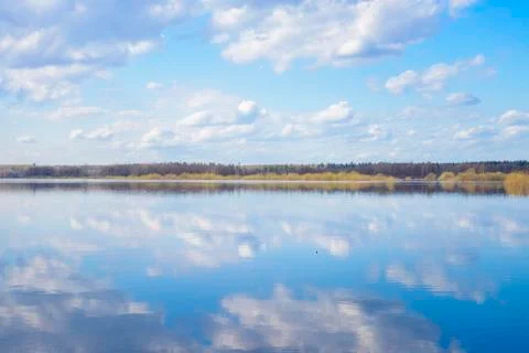 Blue sky and clouds reflected in the river. Ripples on the surface of the wat Foto stock