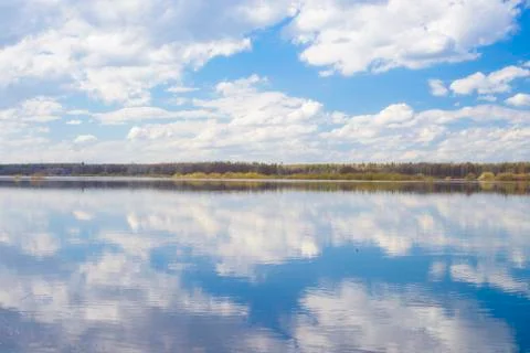 Blue sky and clouds reflected in the river. Ripples on the surface of the wat Foto stock