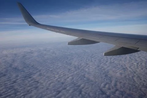 Blue sky and clouds view from an illuminator with a wing Фото