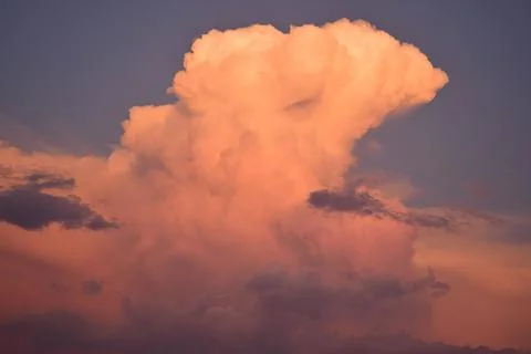 Blue sky and a large cloud with the colors of the sunset Stock Photos