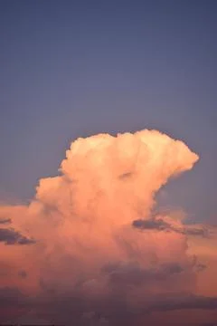 Blue sky and a large cloud with the colors of the sunset Stock Photos