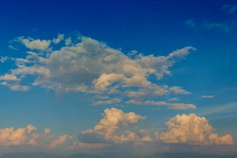 Blue sky and moving clouds during sunset in the summer Stock Photos