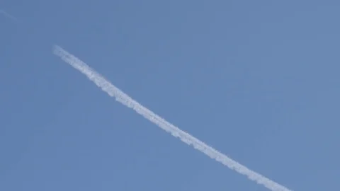 Blue sky and water-based contrails from engine exhaust Stockbeeldmateriaal 81825287