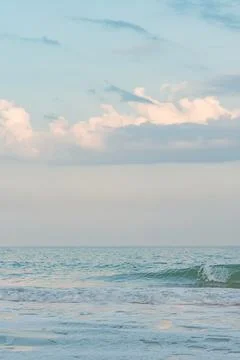 Blue sky and white cloud. Small waves on the sea water. Stock Photos