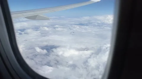 Blue sky and white clouds in airplane window Stock Footage 199040834