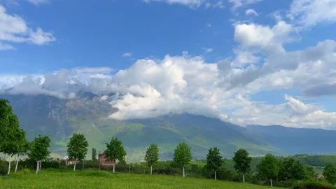 Blue sky and white clouds over lush green mountain landscape Stock Footage 310246119