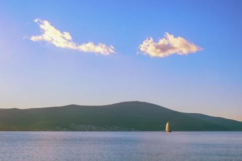 Blue sky and white clouds, white sailboat on blue water. Montenegro Stock Photos