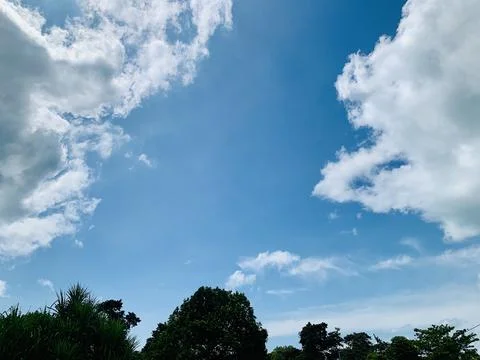 Blue Sky and White Clouds Above Tropical Trees at Tanjung Lesung Beach Stock Photos